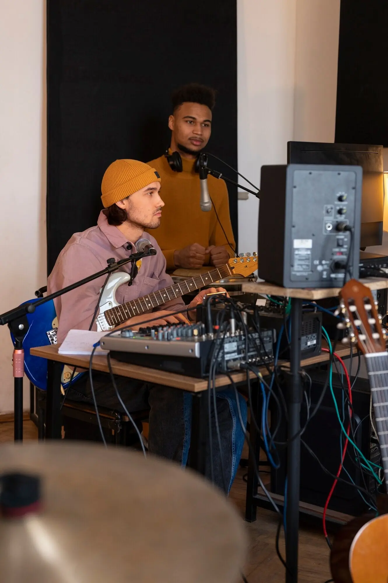 Musiker bei der Arbeit im Studio, von der Seite gesehen.
