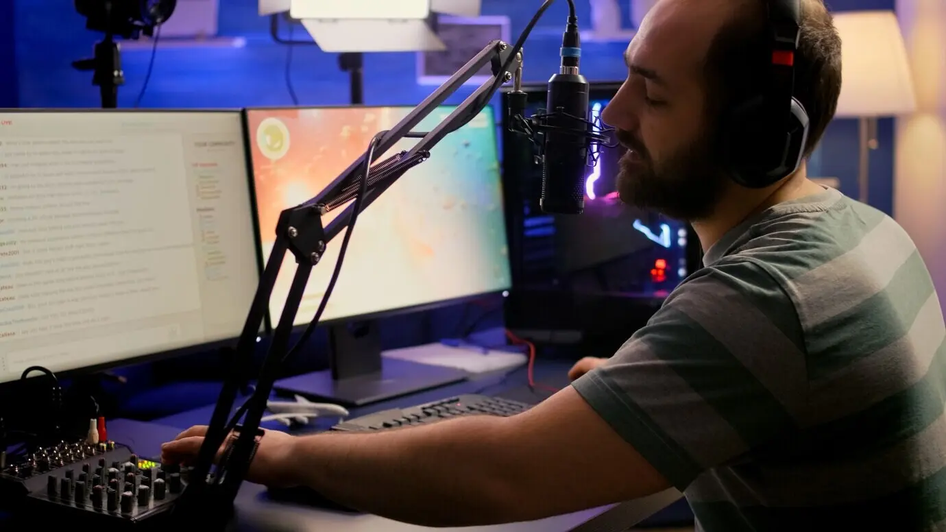 Ein professioneller digitaler Spieler mit Kopfhörern streamt ein Videospiel mit moderner Grafik für eine Online-Shooter-Meisterschaft.